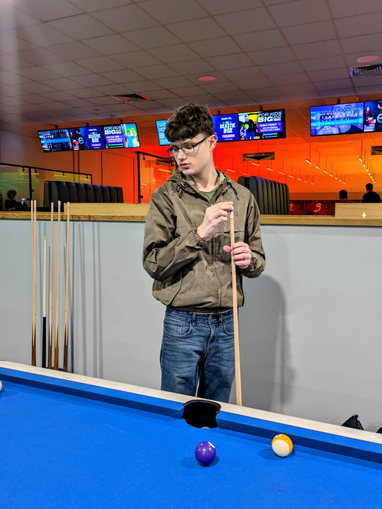 Preston Arnold at a pool table chalking his cue
